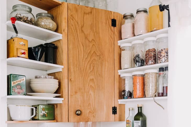 woman organizing kitchen cabinets budget organization.jpg exemplo de mulher mostrando como 5 passos simples para transformar seu pequeno espaço: como organizar a cozinha gastando pouco
